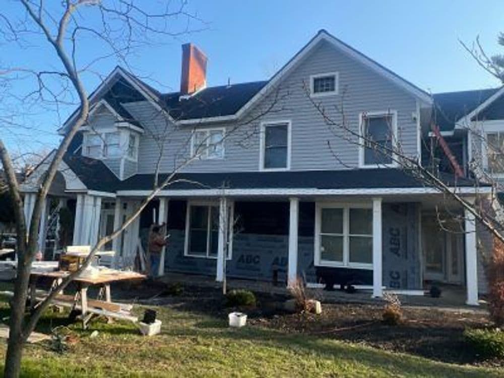 Victorian style house under renovation with scaffolding and construction materials in yard.